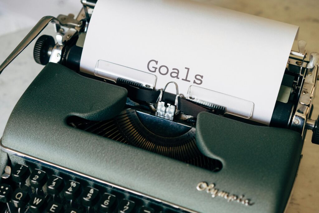 Close-up of a vintage typewriter with the word 'Goals' on paper, symbolizing planning.